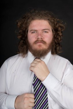 Plus size male with long curly hair and a beard wearing a business suit