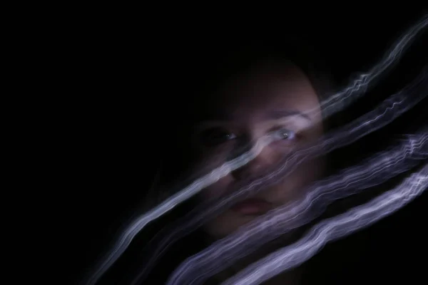 plus size woman with long exposure light trails in front of face