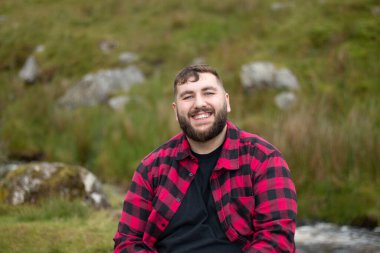 plus size male wearing a checkered shirt out on a travel adventure