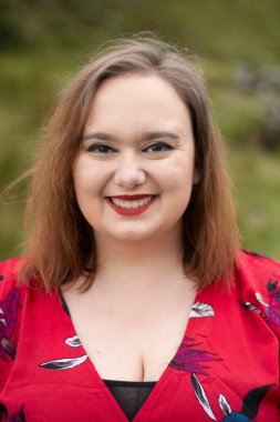 Close up portrait of plus size female with a red dress and red lipstick taken outside on a travel adventure