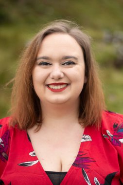 Close up portrait of plus size female with a red dress and red lipstick taken outside on a travel adventure