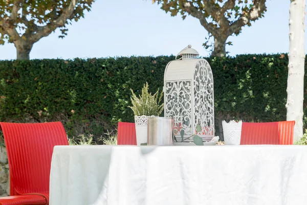 Cage-shaped oil lamp on an outdoor garden table.