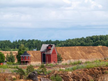 Falun Copper Mine the World Heritage with orange mountain visible and tourist spot in background.