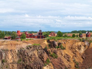 Falun Copper Mine the World Heritage with orange mountain visible and tourist spot in background.