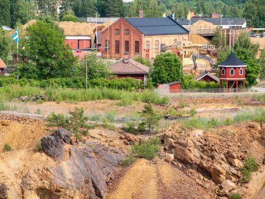 Falun Copper Mine the World Heritage with orange mountain visible and tourist spot in background.