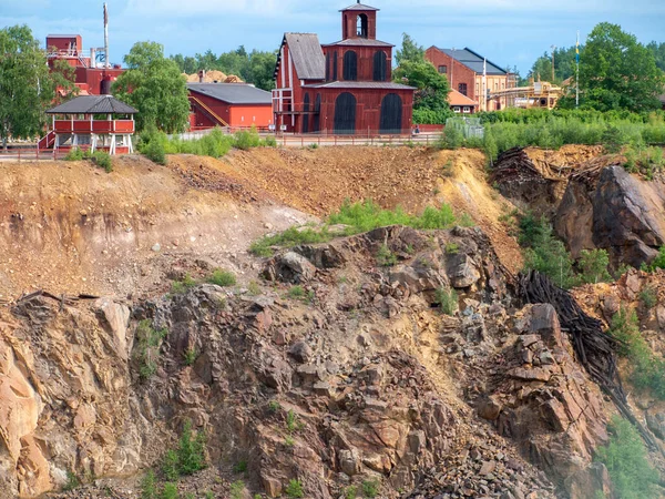 Falun Copper Mine the World Heritage with orange mountain visible and tourist spot in background.