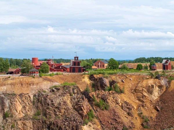 Falun Copper Mine the World Heritage with orange mountain visible and tourist spot in background.