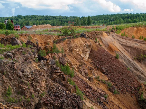 Falun Copper Mine the World Heritage with orange mountain visible and tourist spot in background.