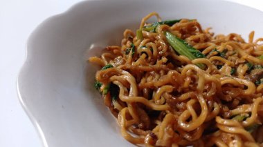 noodles cooked with a mixture of mustard greens with white background