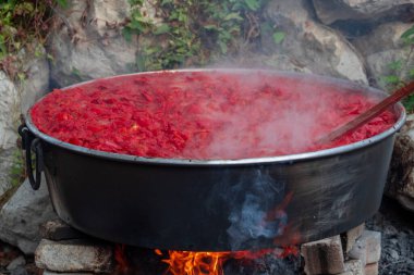 Traditional tomato paste making on the wood fire in cauldrons on the street, selective focus