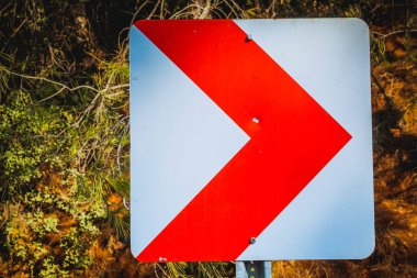 Right signpost on the road, traffic sign, white sign on the red background, trees, greenlife, selective focus