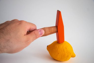Hand held wooden handle hammer and orange head, on the lemon, isolated white background, straight peen hammer, selective focus