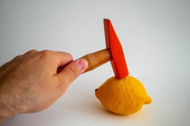 Hand held wooden handle hammer and orange head, on the lemon, isolated white background, straight peen hammer, selective focus