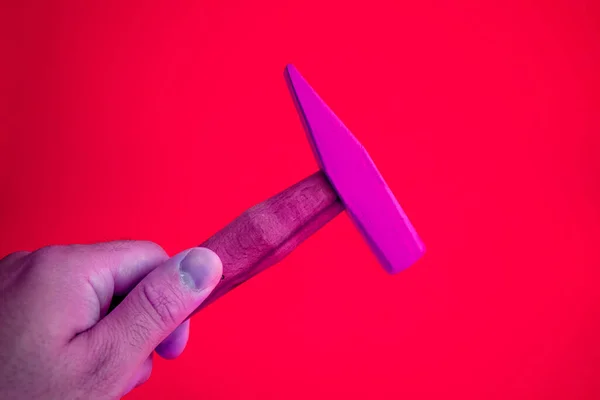 Purple Hand held wooden handle hammer and purple head, isolated red background, straight peen hammer, selective focus