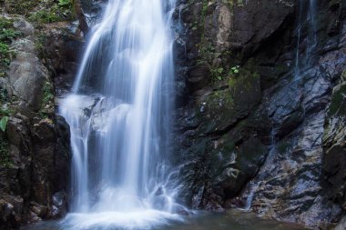 Inegol, Bursa, Türkiye - Eylül 2022: Oylat Şelalesi, ormandaki güzel bir şelalenin uzun pozlu fotoğrafları, insan oturma silueti, seçici odaklanma