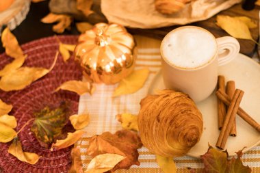 Kurabiyeli kahve ve ahşap masada kruvasan.