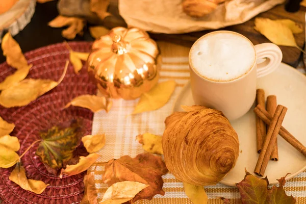 Kurabiyeli kahve ve ahşap masada kruvasan.