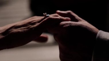 Bir adam alyansla bir kızın elini tutuyor.