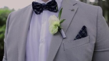 a man in a gray suit walks in the park