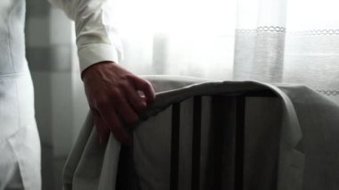  a man takes a jacket from a suit