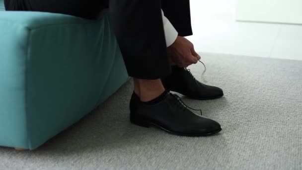 朝黒い靴に靴ひもを結ぶ男 — ストック動画