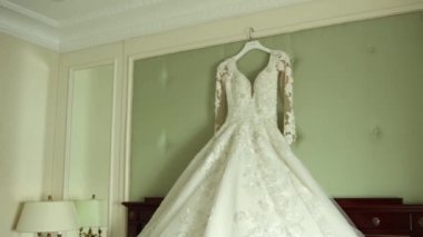 Gelinin gelinliği yatağın üstünde şık bir odada.