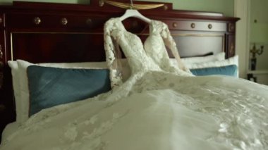 Gelinin gelinliği yatağın üstünde şık bir odada.