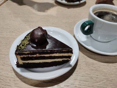 Beyaz kremalı çikolatalı kek ve bir fincan kahve.