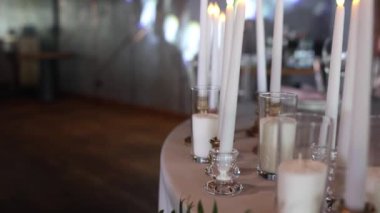 Bir restorandaki şenlikli düğün masasının üzerindeki mumlardan bir dekor.