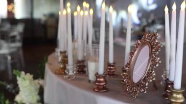Bir restorandaki şenlikli düğün masasının üzerindeki mumlardan bir dekor.