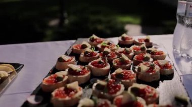 Aperatiflerin şenlikli masasında kırmızı havyar kanepesi.