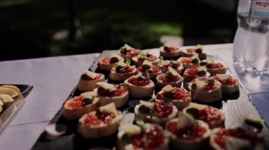 Aperatiflerin şenlikli masasında kırmızı havyar kanepesi.