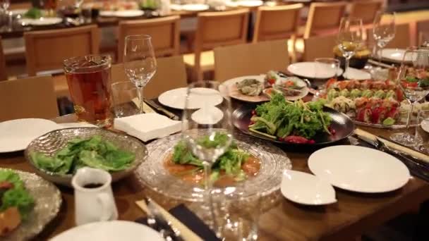 レストランのテーブルの上に前菜とサラダ付きのお祝いのテーブル — ストック動画