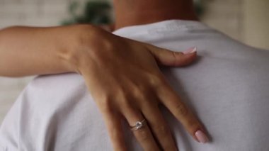 Kız elini adamın sırtına uzatıyor.