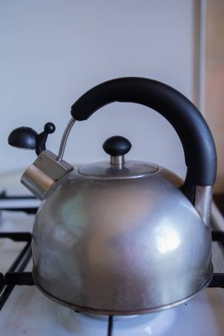 Ocakta ıslık çalan metal bir çaydanlık.