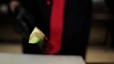 Şef mutfakta suşi için avokadoyu bıçakla keser.