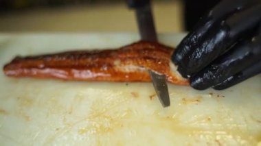 Aşçı şefi unagi soslu Japon mutfağıyla yılan balığı keser.