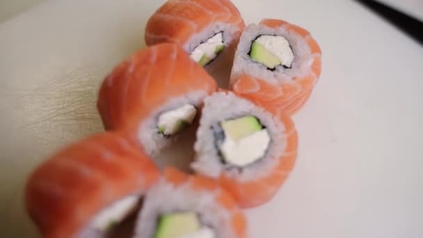 お皿の上に鮭とクリームチーズを乗せた日本の寿司ロール — ストック動画