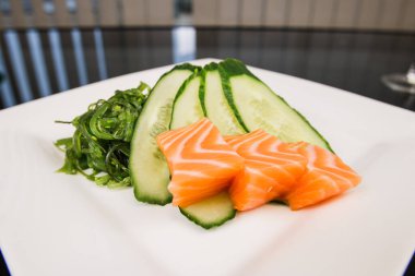 Restoranda salatalıklı bir somon balığı ve Japon algleri var.