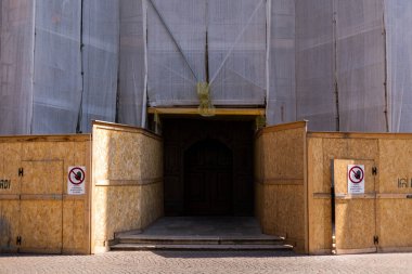 Kumaş ve iskelelerle kaplı bir inşaat alanında bir bina.