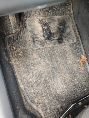 Çamur ve yağmurdan sonra arabada kirli bir lastik paspas.