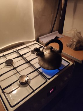 Mutfaktaki gaz ocağında metal bir çaydanlık.