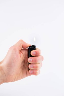 Bir gaz çakmağı beyaz arka planda ateş yakar