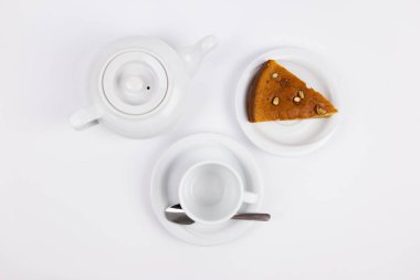 Çay, kahve ve çaydanlık için fincan tabağında bir parça kek.