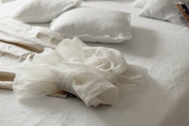 Yastıklı ve yataklı otel odasında yatağın üstünde dekor.