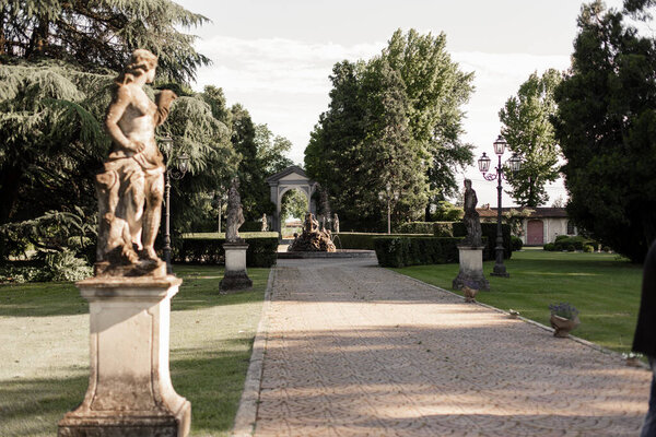 beautiful alley in the park with statues in italy