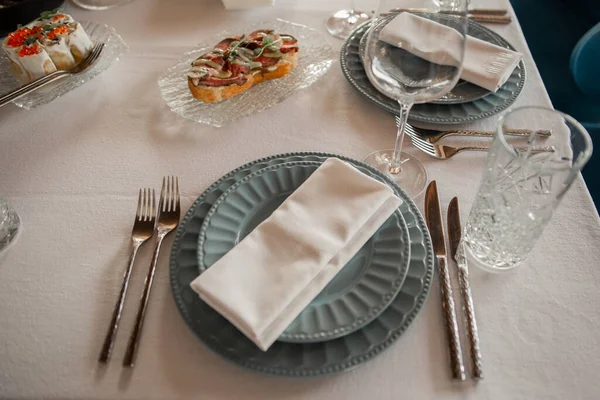 a serving plate with cutlery on the table in the restaurant