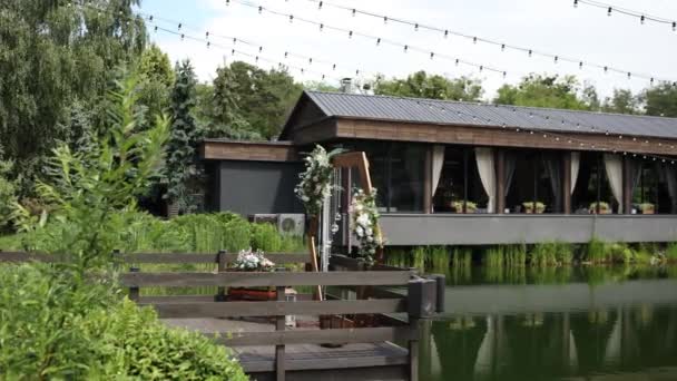 結婚式のためのアーチは夏に庭の水の上に立つ — ストック動画