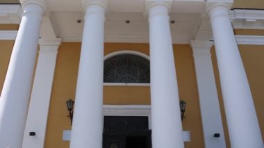 Beyaz kolonları olan Katolik kilisesine giriş.