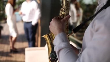 Bir adam bir restoranda tatilde saksafon çalar.